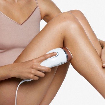 woman using the Silk-expert IPL on her legs from side to side