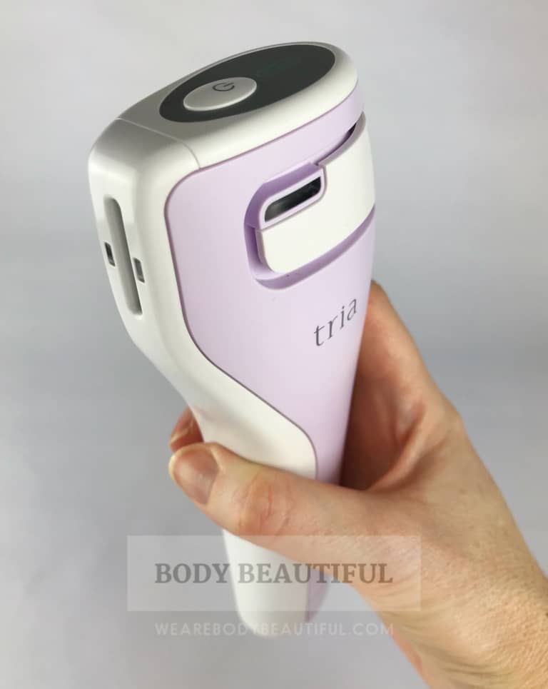 A hand holding the Tria age defying Laser angled towards the camera.