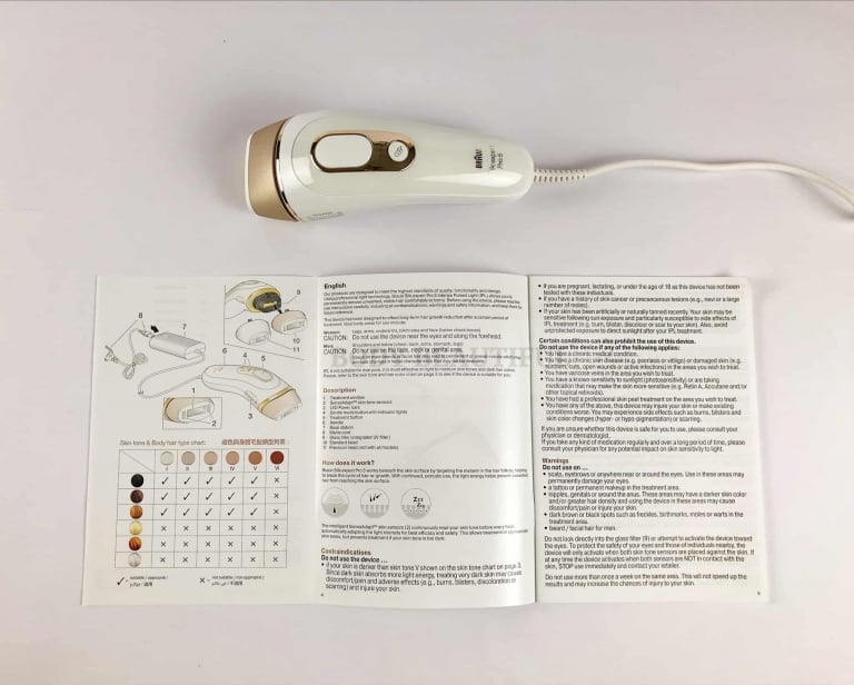 Photo of the Braun Pro 5 IPl device above the user guide booklet open at the skin tone and hair colour chart page
