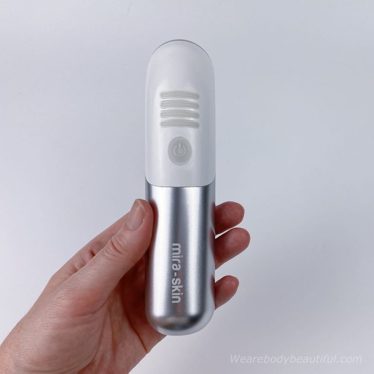 My hand holding the small white and silver Mira-skin ultrasound wand